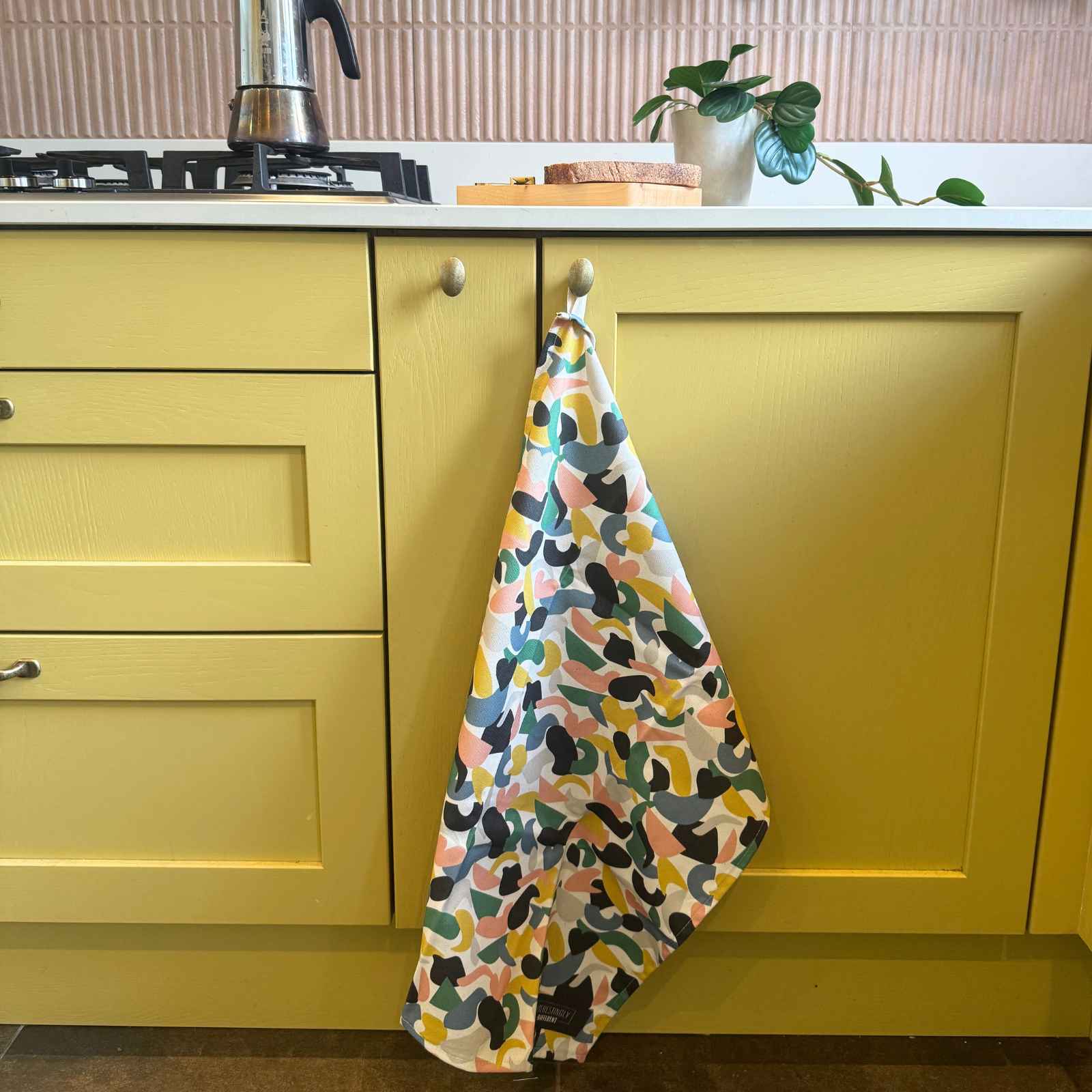 colourful teatowel on yellow cupboard